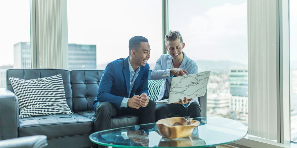 two men in suit sitting on sofa