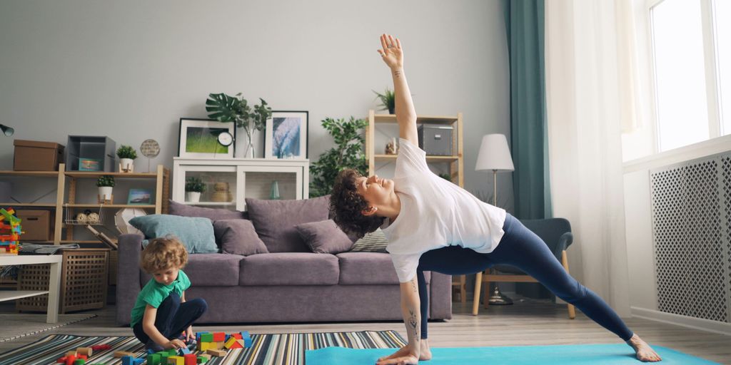 a woman and a child doing yoga in a living room