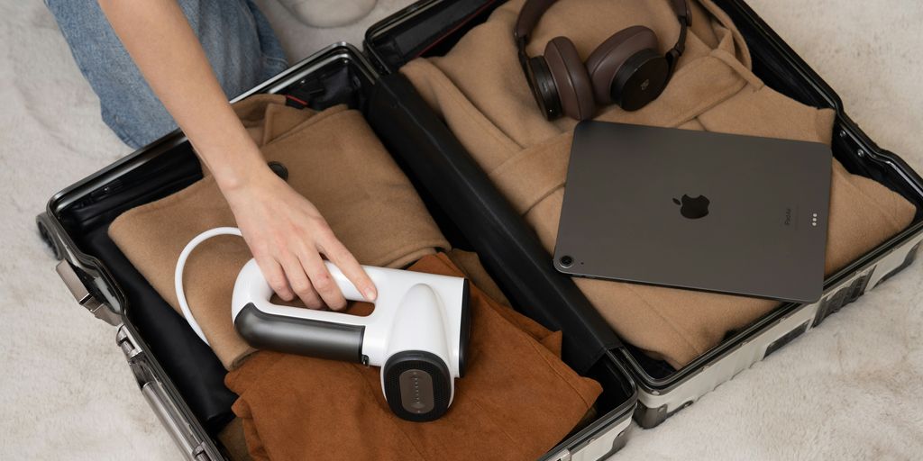 A person sitting on the floor with a laptop in a suit case