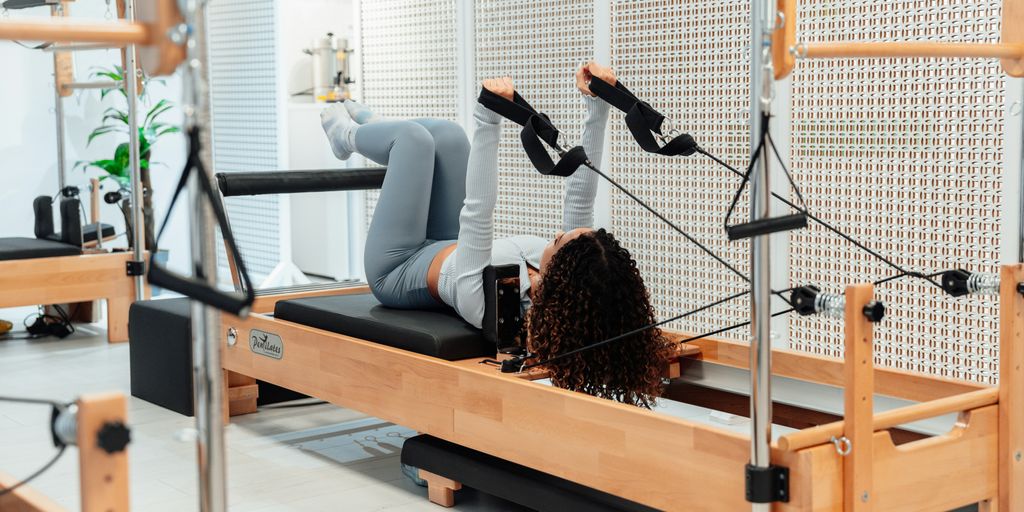 a woman is doing exercises on a rowing machine