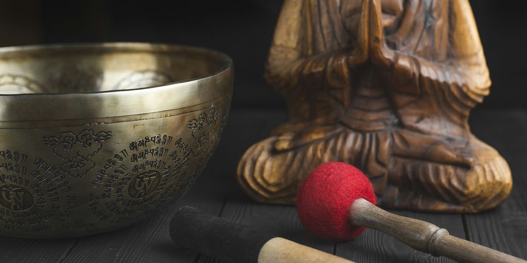 brass buddha figurine beside red and white stick