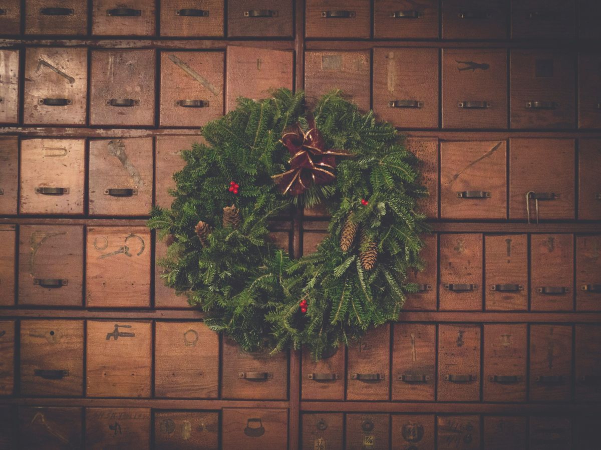 green and brown pinecone Christmas wreath on wooden drawers
