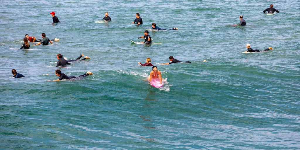 a group of people riding surfboards on top of a wave