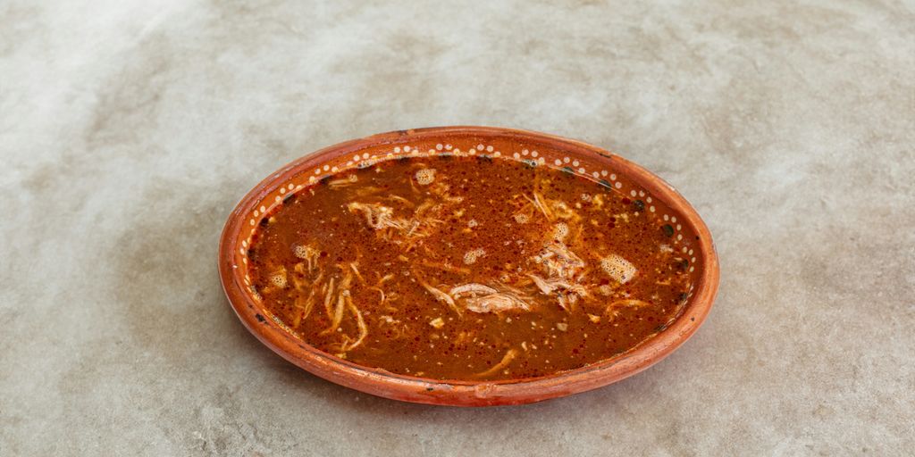 A small orange bowl sitting on top of a table