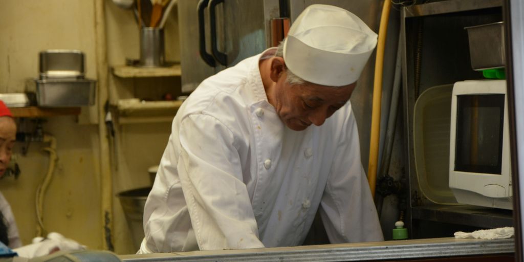 man in white chef uniform sitting on train seat
