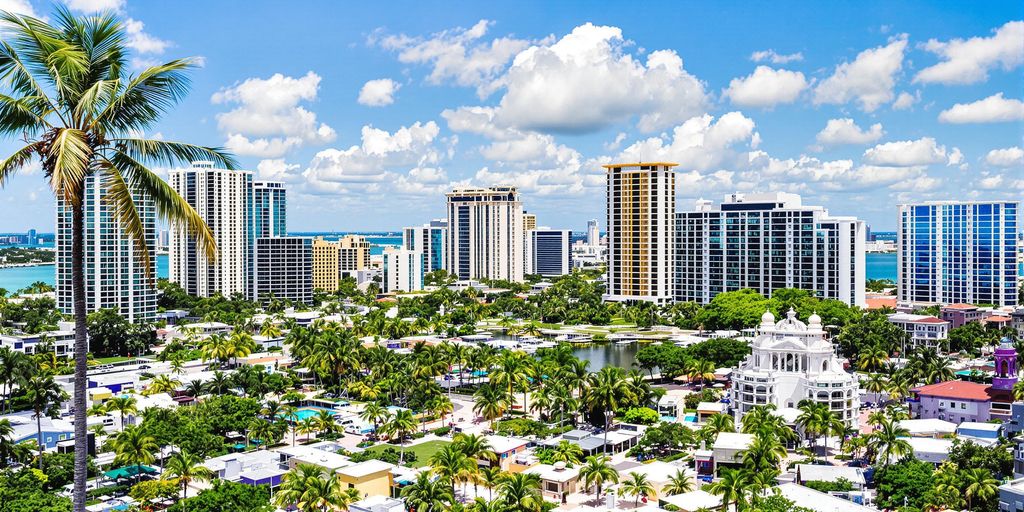 Vibrant Aventura skyline with palm trees and clear skies.