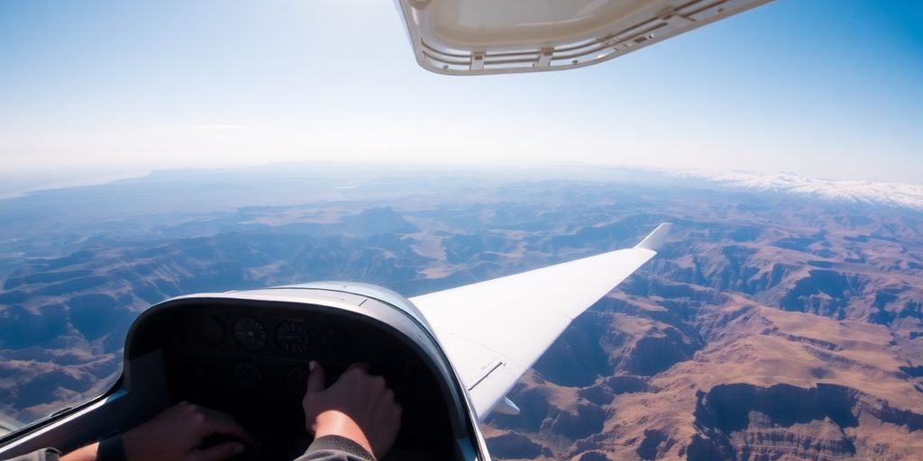 Pilot in cockpit flying a small plane over mountains.