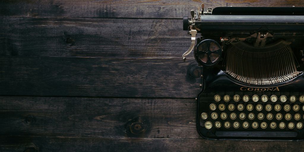black Corona typewriter on brown wood planks