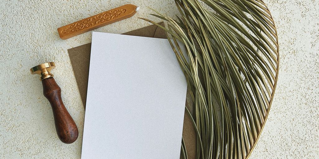 a white piece of paper with a brown handle and a wooden spoon