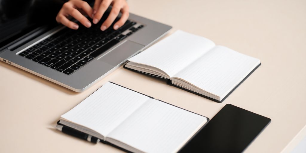 Laptop, open book, and pen on desk.