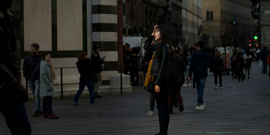 person in black top standing beside road