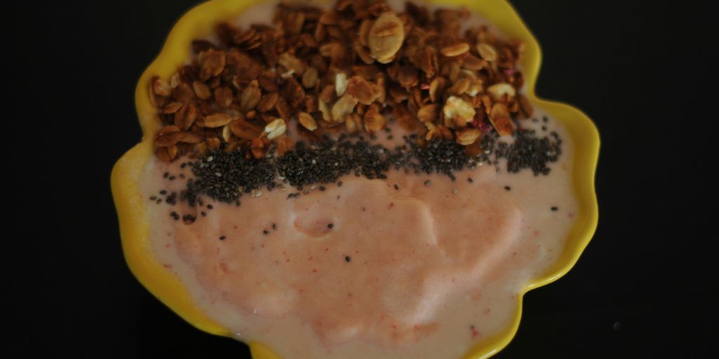 A yellow plate topped with a dessert covered in nuts