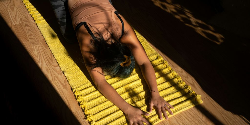 woman in black tank top lying on yellow hammock