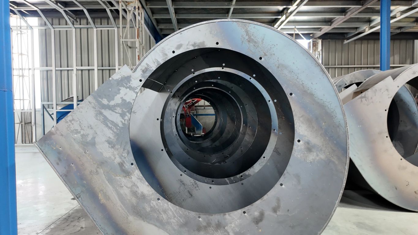 Metal spiral structure in an industrial setting with circular openings.