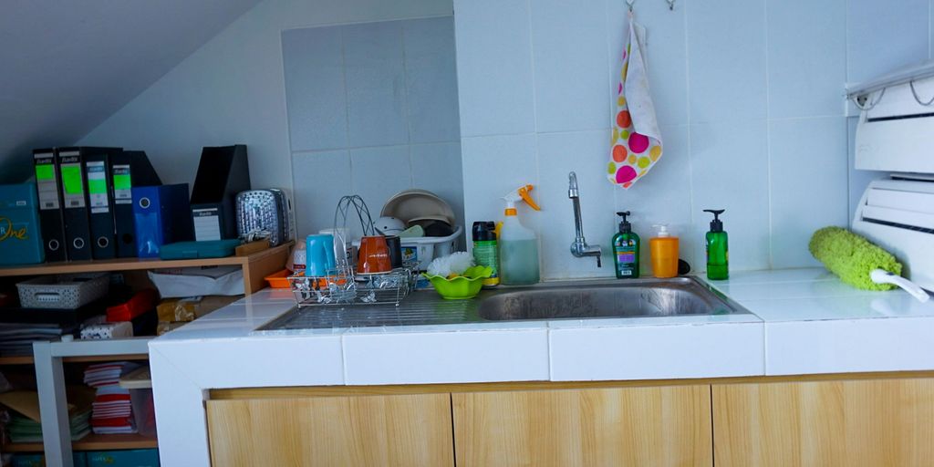 a kitchen with a sink and a lot of clutter on the counter