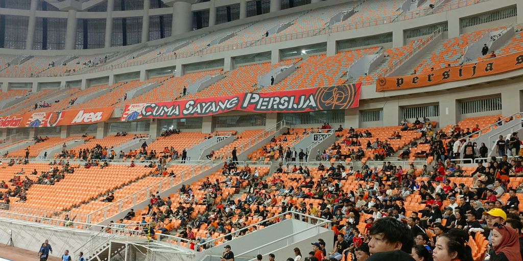 a large crowd of people sitting in a stadium