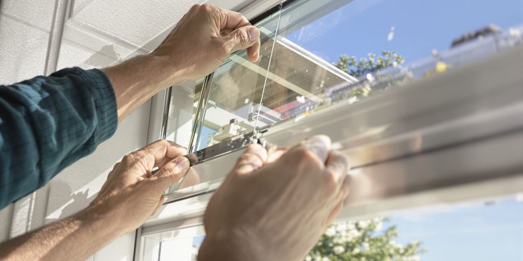 Hand installing a window during summer.
