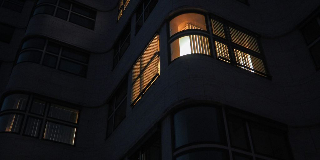 a tall building with windows lit up at night