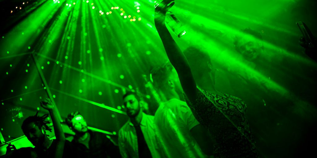 a group of people standing in front of a green light