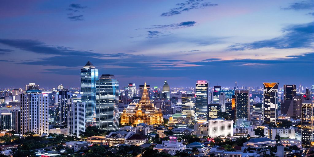 Luxurious Bangkok skyline with modern high-rises at night.
