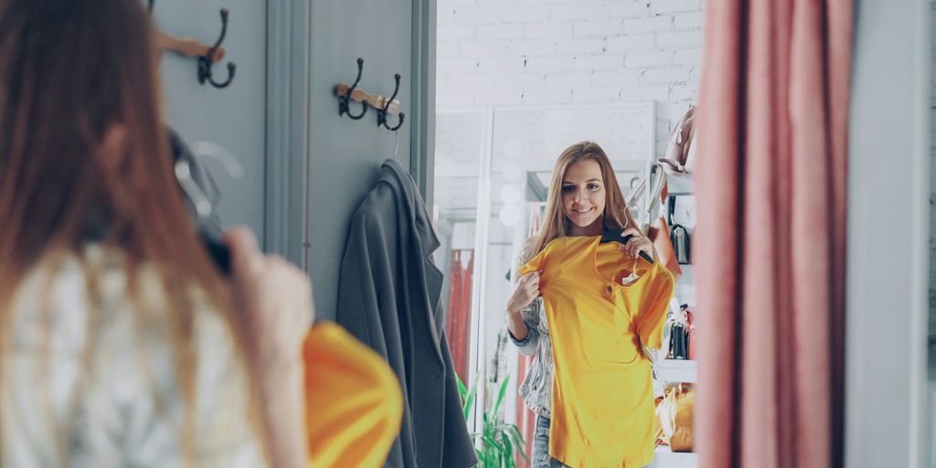 Woman tries on clothes in a dressing room.