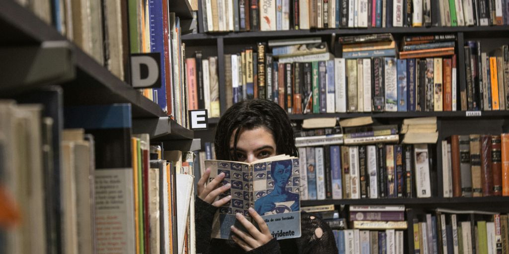 woman holding book covering half face