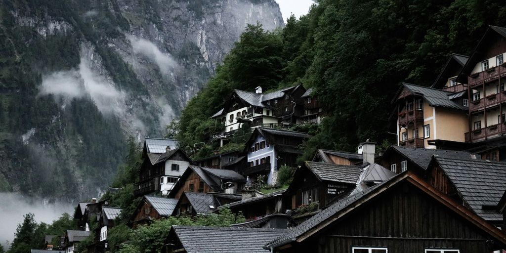 wooden houses near trees covered mountain during daytime