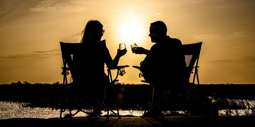 a man and woman sitting on a chair at the beach