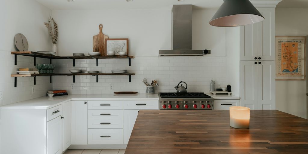 a kitchen with a wooden counter top next to a stove top oven