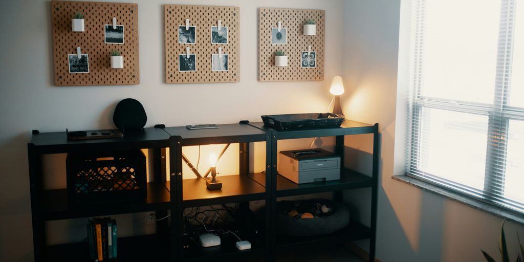 a desk with a lamp and pictures on the wall