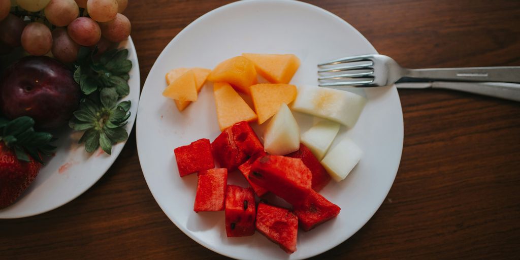 sliced watermelon and mango on plate with fork