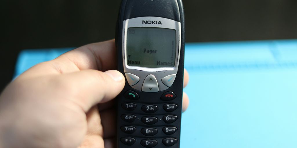 A hand holds a classic nokia cell phone.