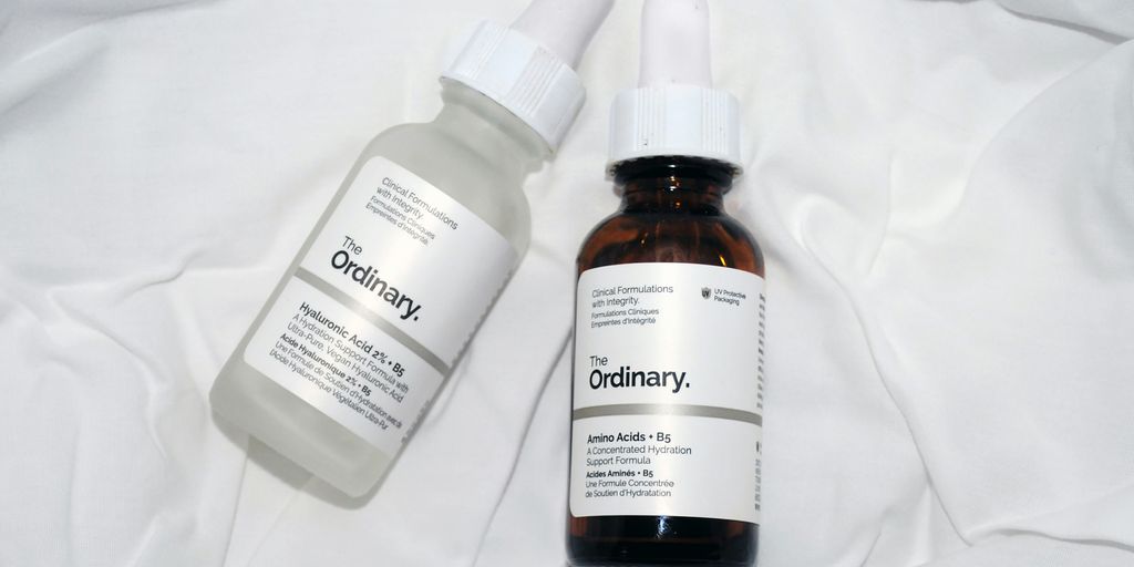 a couple of bottles of liquid sitting on top of a bed