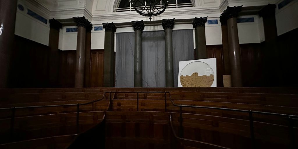 an empty church with a chandelier hanging from the ceiling