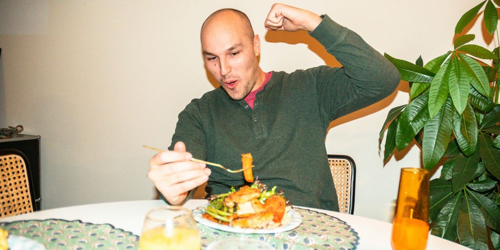 a man sitting at a table with a plate of food
