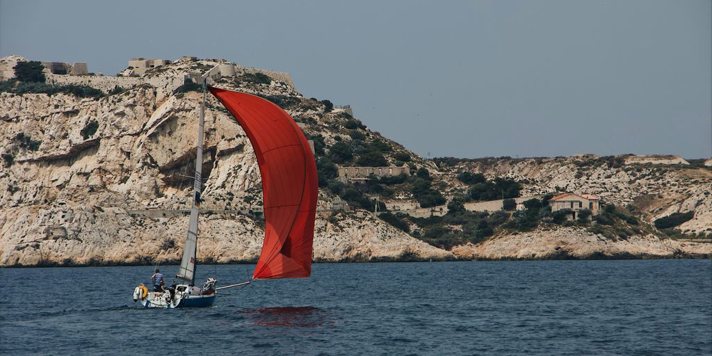 red and gray sailboat on seat during daytime