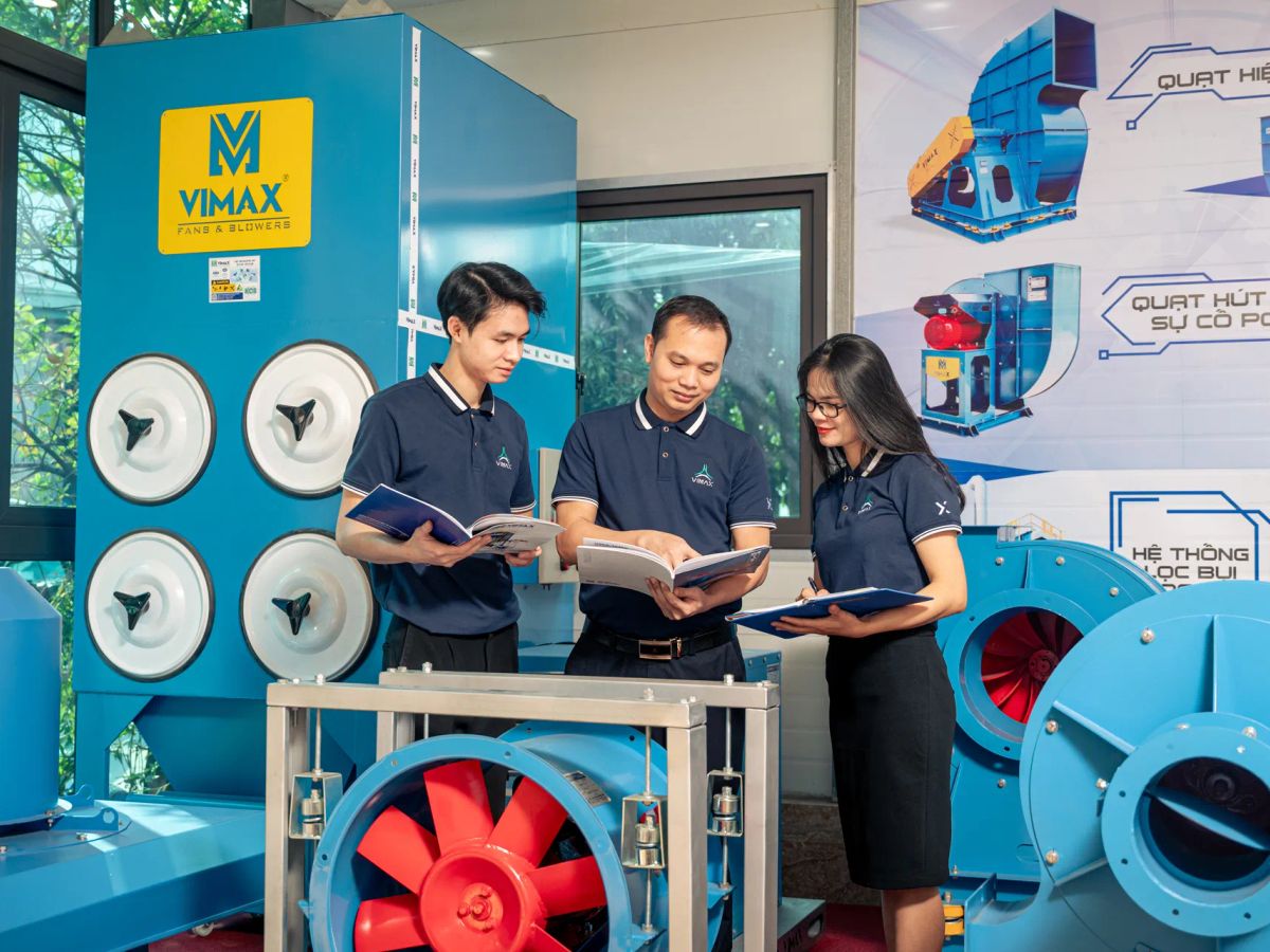 Three professionals discussing equipment in a technical setting.