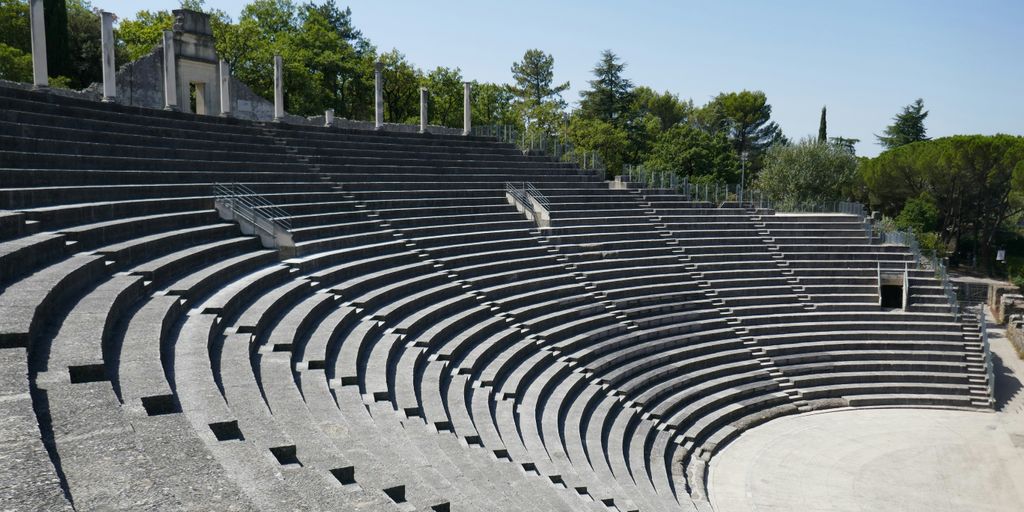 a row of empty seats sitting on top of a cement field