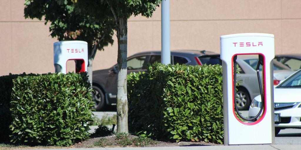 two electric cars parked next to each other in a parking lot