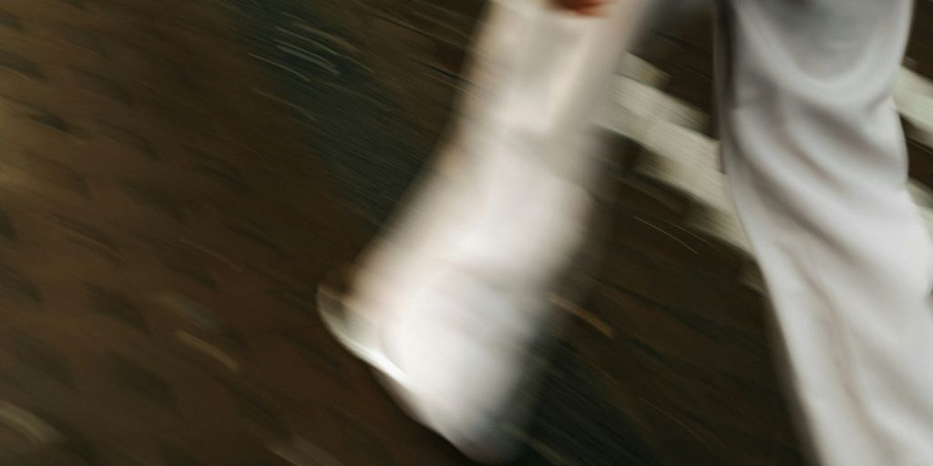 Blurred legs walk across a wooden surface.
