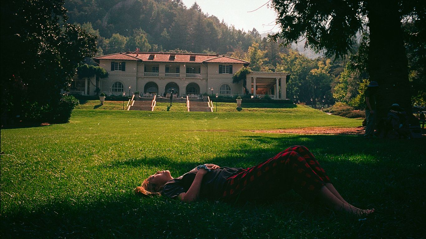 a person laying on the grass in front of a house