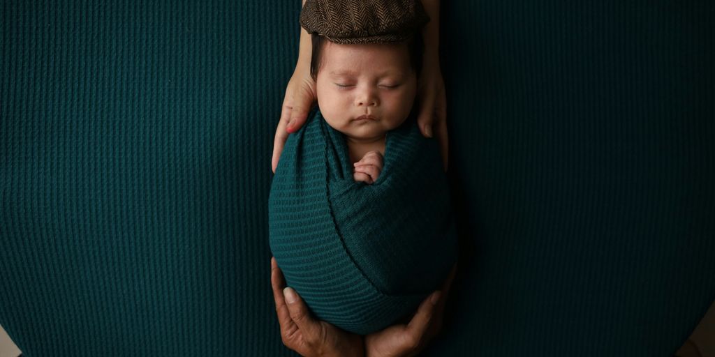 a woman holding a baby wrapped in a blanket