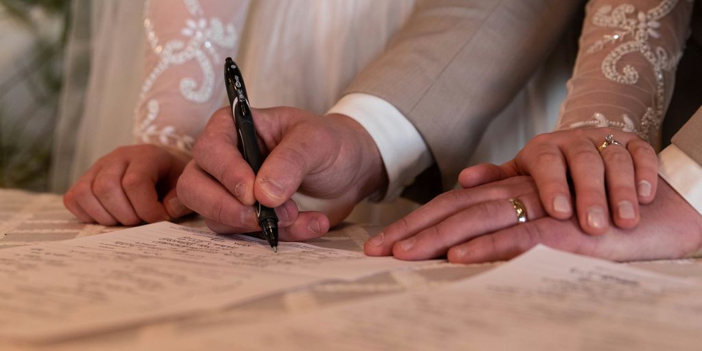 a bride and groom signing their wedding vows