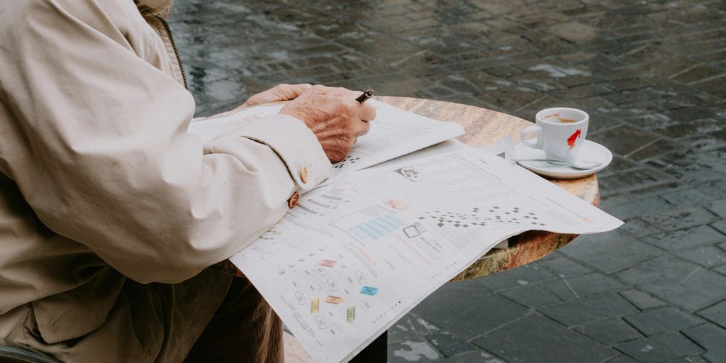 a man sitting at a table writing on a piece of paper