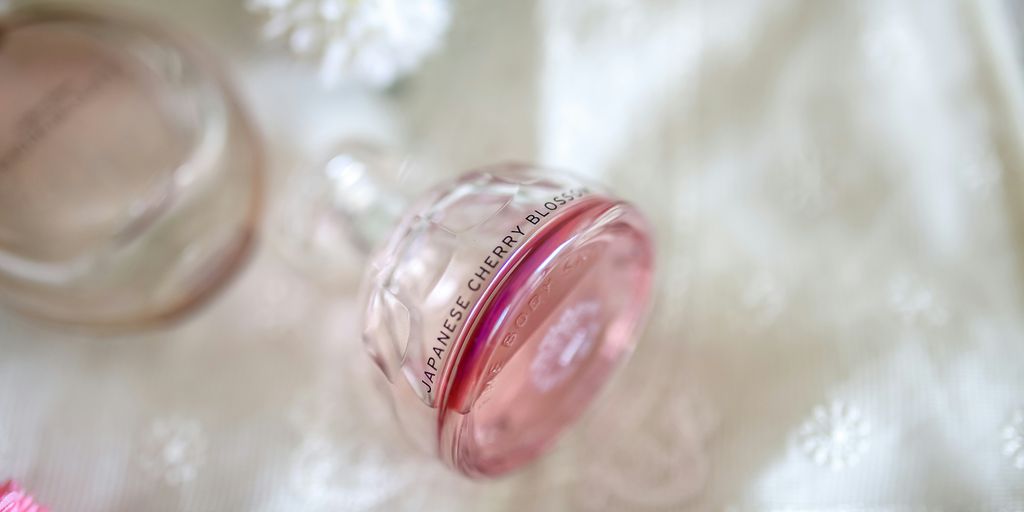 clear Japanese Cherry Blossom fragrance bottle on white textile