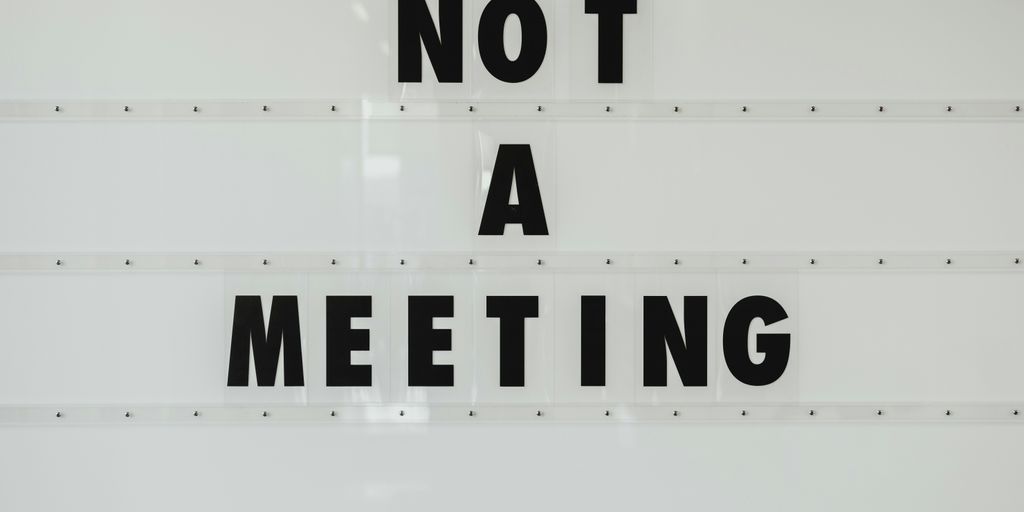 black note a meeting sign on wall