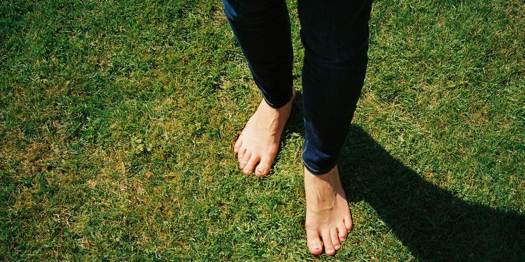 person in blue denim jeans standing on green grass field