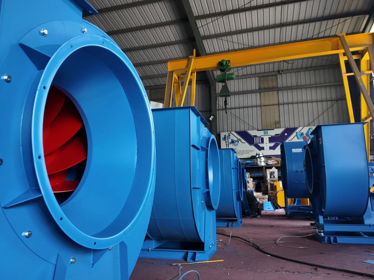 Industrial setting with large blue machinery and ventilation fans.