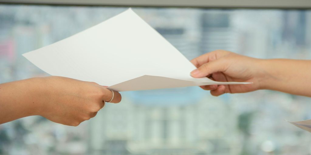 person handing over paper