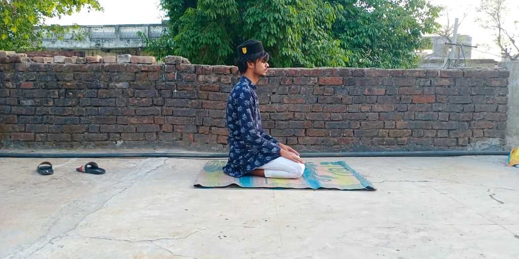 woman in blue and white floral dress sitting on blue mat
